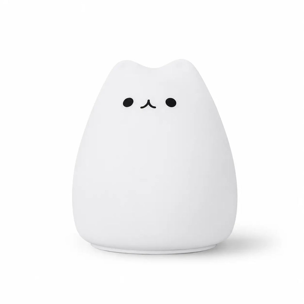 Veilleuse en silicone blanc en forme de petit chat arrondi au design épuré. Elle présente deux petits yeux ronds et un museau noir minimaliste, présentée de face sur un fond blanc uni.