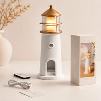 Veilleuse en forme de phare blanc et doré présentée avec sa télécommande son câble usb et sa boîte d'emballage
