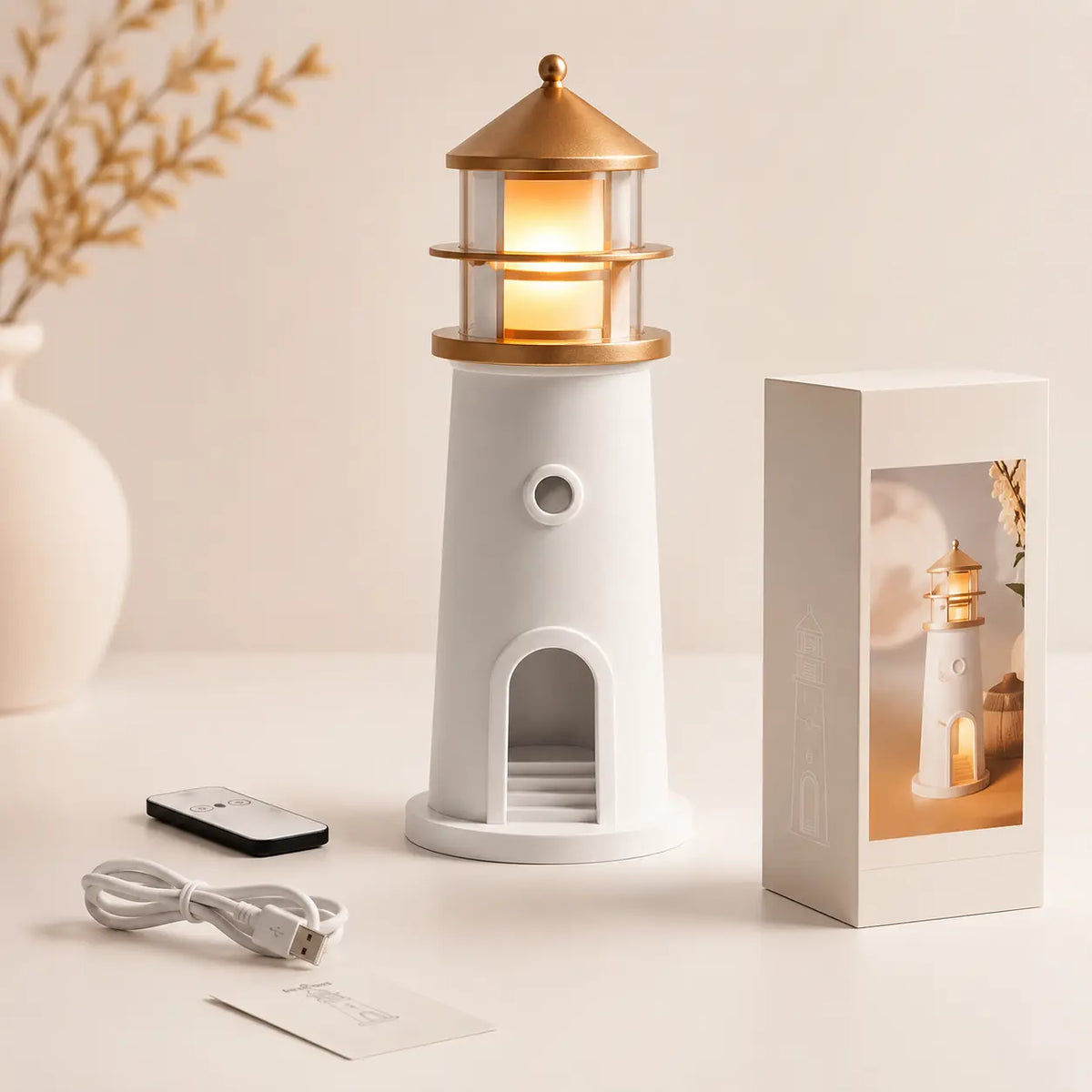 Veilleuse en forme de phare blanc et doré présentée avec sa télécommande son câble usb et sa boîte d'emballage