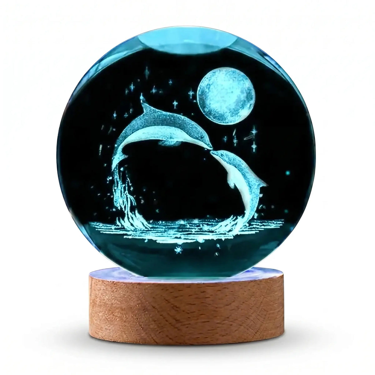 Boule de cristal avec gravure laser 3D de deux dauphins sautant sous la lune sur socle en bois sur fond blanc