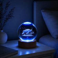 Boule de cristal tortue marine allumée sur une table de chevet dans l'obscurité d'une chambre