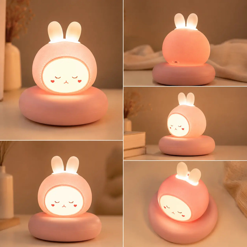 Grille de cinq photos présentant une veilleuse rose en forme de tête de petit lapin allumée sous différents angles de vue. Le produit est posé sur son large socle circulaire assorti au milieu d'un décor de chambre épuré. Les vignettes montrent la veilleuse de face, de dos révélant la coque rose et le port de charge, de trois-quarts et selon une vue plongeante mettant en avant ses deux petites oreilles blanches lumineuses.