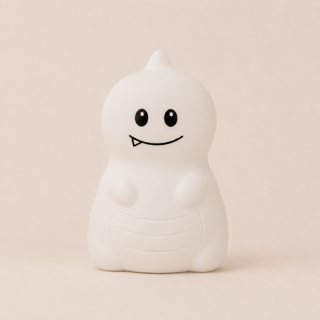 Veilleuse en silicone allumée en forme de petit dinosaure blanc, sur un fond beige neutre.