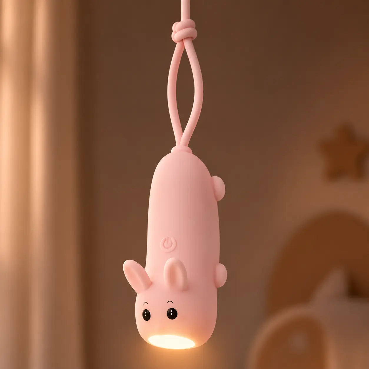 Lampe torche lapin rose allumée et suspendue par sa dragonne.