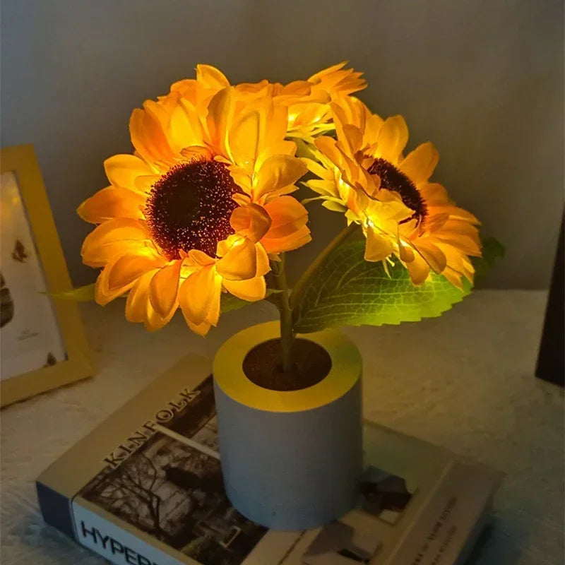 Gros plan sur une lampe tournesol led en forme de bouquet de fleurs artificielles éclairé posée sur un livre