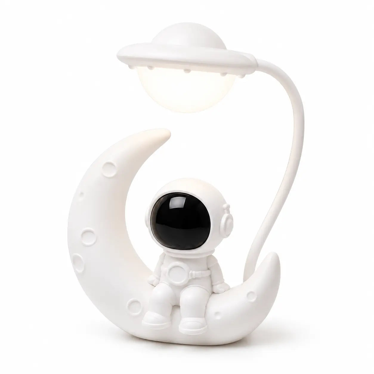 Veilleuse blanche originale mettant en scène un petit astronaute assis sur un croissant de lune texturé. Une tige flexible blanche part de l'arrière pour suspendre une lampe en forme de soucoupe volante illuminée au-dessus du personnage, présentée de trois-quarts face sur fond blanc.