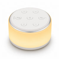 Machine à bruit blanc et veilleuse pour bébé allumée de forme cylindrique, diffusant une lueur jaune chaleureuse. La face supérieure blanche intègre des boutons de contrôle épurés pour le réglage du volume, de la lumière, des pistes audio et de la minuterie (30, 60, 90 minutes), présentée sur fond blanc.