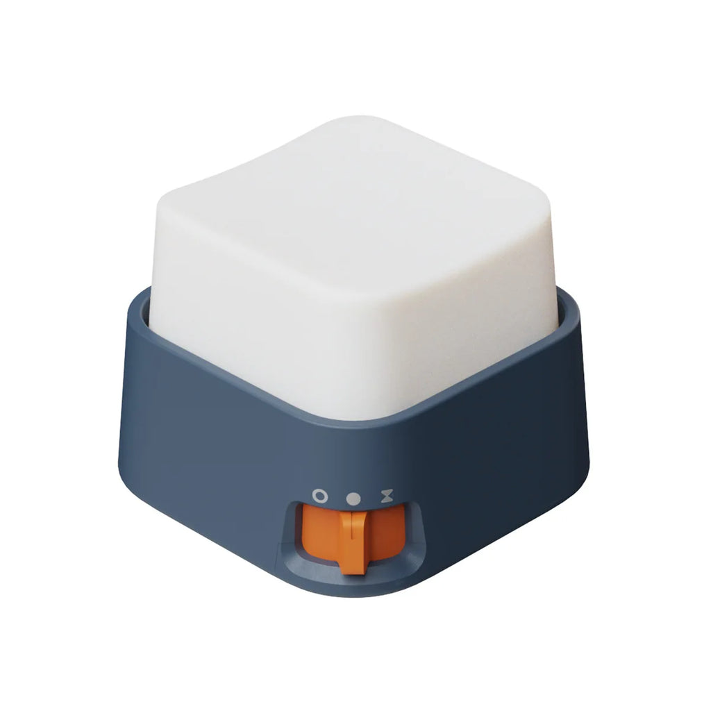 Mini veilleuse anti-stress cubique blanche avec base bleu nuit et interrupteur orange sur fond blanc