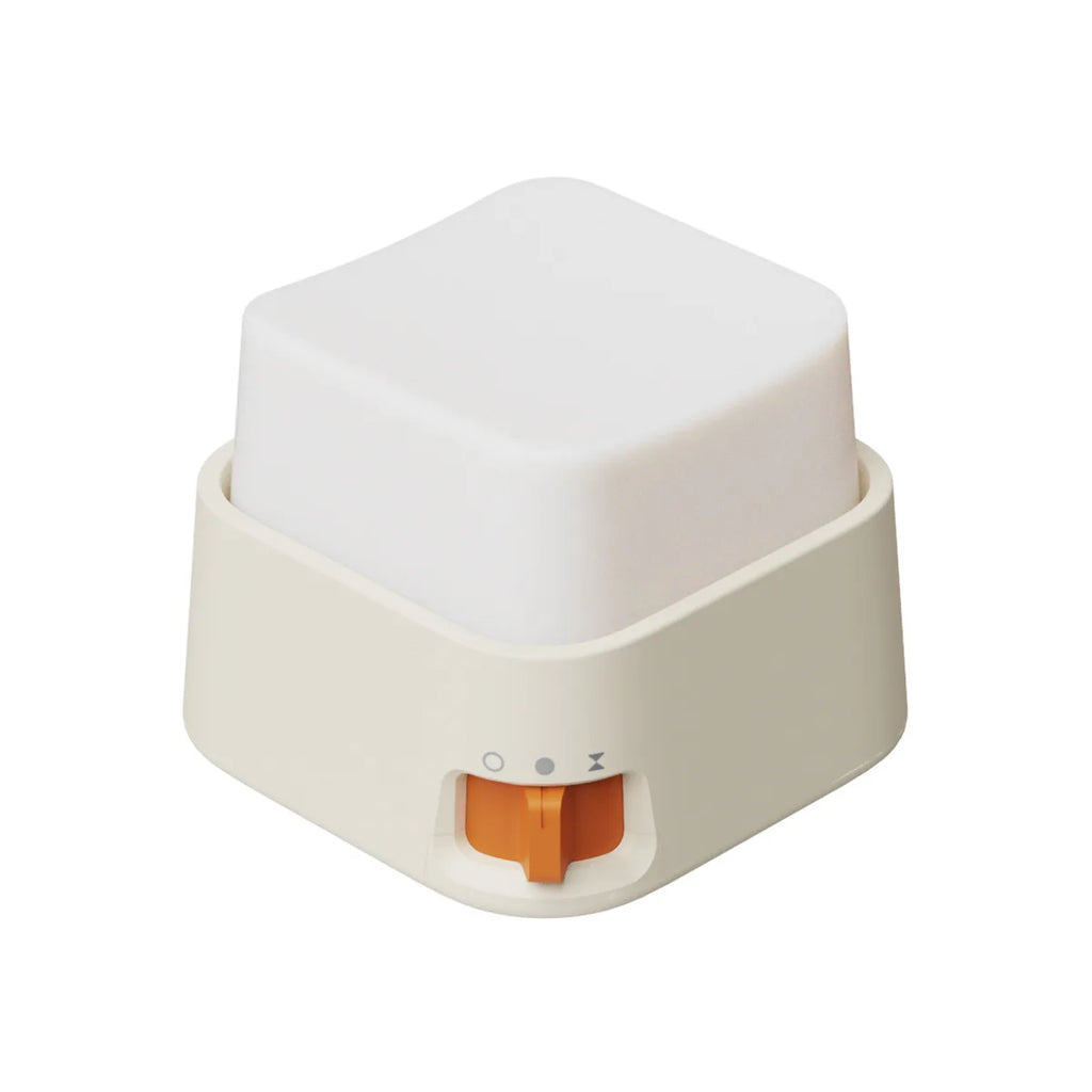 Mini veilleuse anti-stress cubique blanche avec base beige et interrupteur orange sur fond blanc