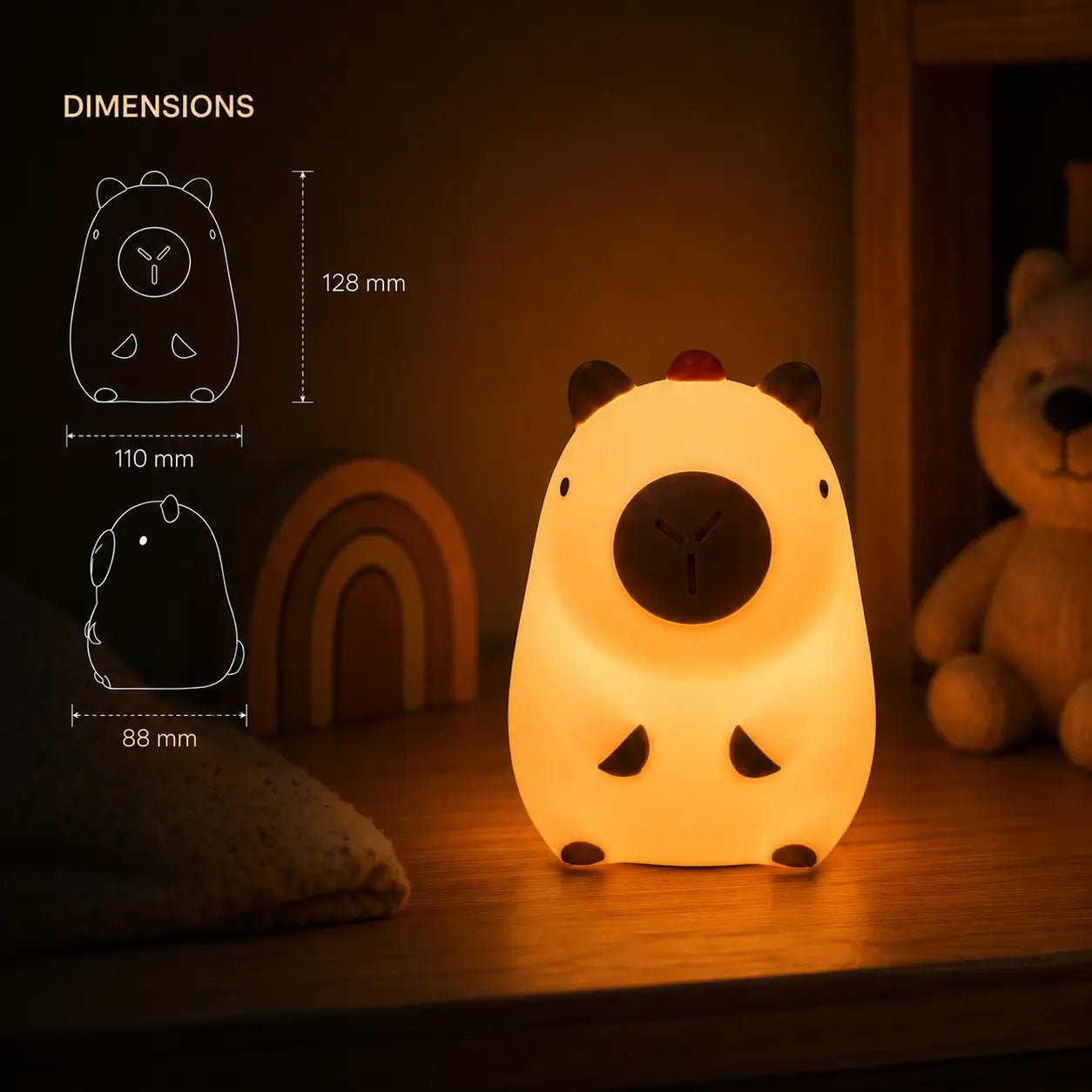 Schéma des dimensions de la petite veilleuse capybara indiquant une hauteur de 128 mm, une largeur de 110 mm et une profondeur de 88 mm, à côté de la veilleuse allumée.