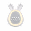 Réveil lapin LED blanc avec un anneau lumineux allumé autour de l'écran numérique affichant l'heure sur fond blanc.