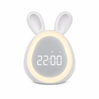 Réveil lapin LED blanc avec un anneau lumineux allumé autour de l'écran numérique affichant l'heure sur fond blanc.