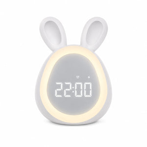 Réveil lapin LED blanc avec un anneau lumineux allumé autour de l'écran numérique affichant l'heure sur fond blanc.