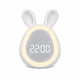 Réveil lapin LED blanc avec un anneau lumineux allumé autour de l'écran numérique affichant l'heure sur fond blanc.