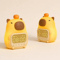 Deux réveils veilleuses capybara allumés de face et de profil diffusant une lumière chaude.