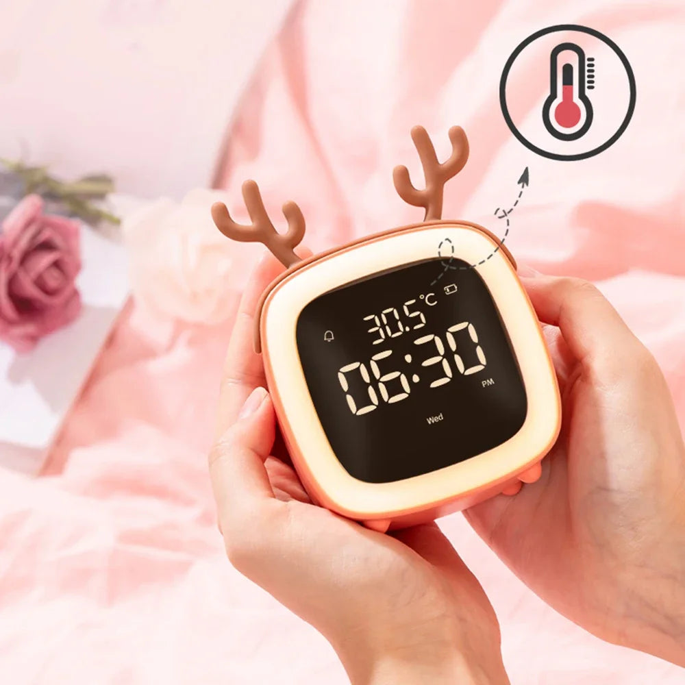 Réveil de chevet bois de cerf corail tenu dans les mains affichant la température de la pièce avec un pictogramme thermomètre.