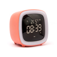 Réveil veilleuse de chevet classique couleur corail avec son écran numérique rétroéclairé sur fond blanc.