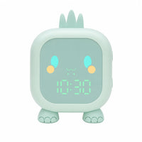 Réveil veilleuse dinosaure de couleur verte vu de face avec son affichage numérique lumineux sur fond blanc.