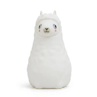 Veilleuse en silicone en forme de petit alpaga blanc sur fond blanc.