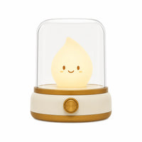 Veilleuse bougie LED de couleur beige éteinte sur fond blanc avec sa base dorée.