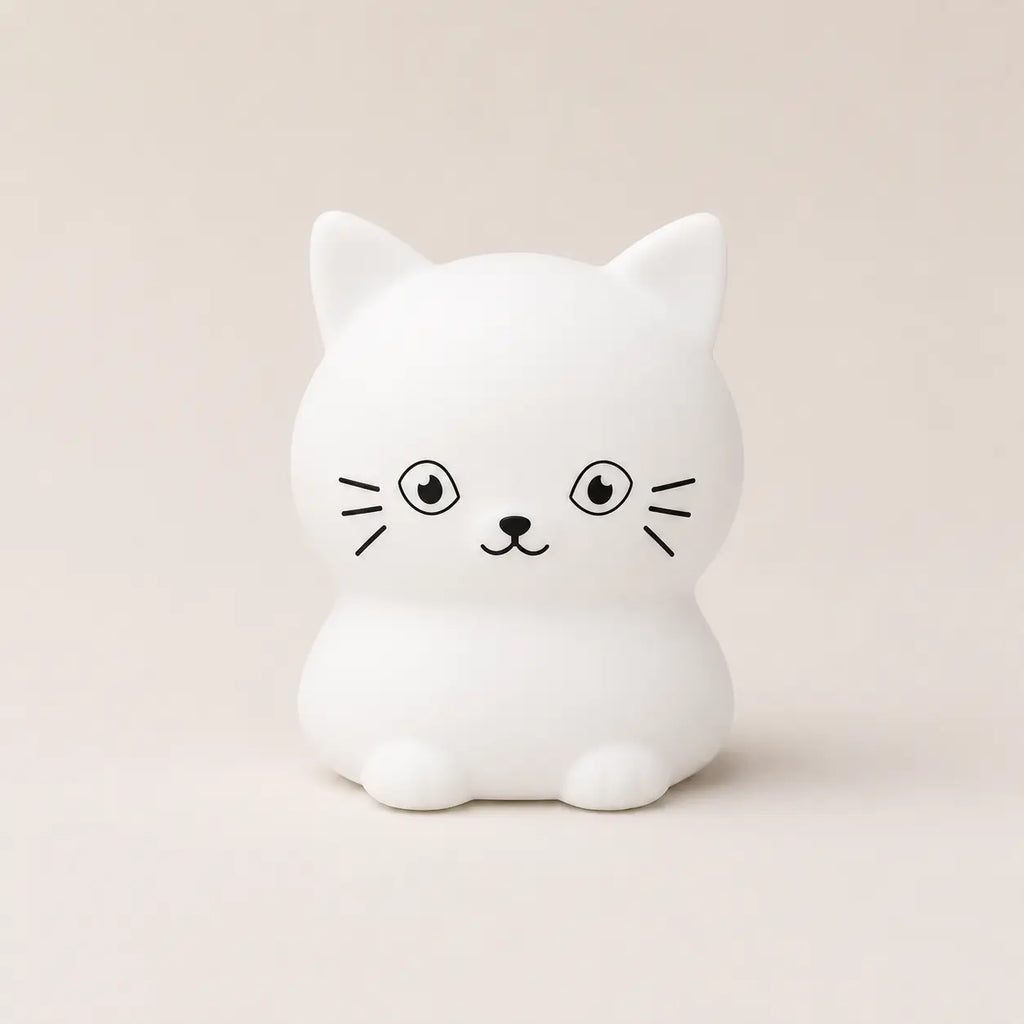 Veilleuse en silicone en forme de petit chat blanc, sur un fond beige neutre.