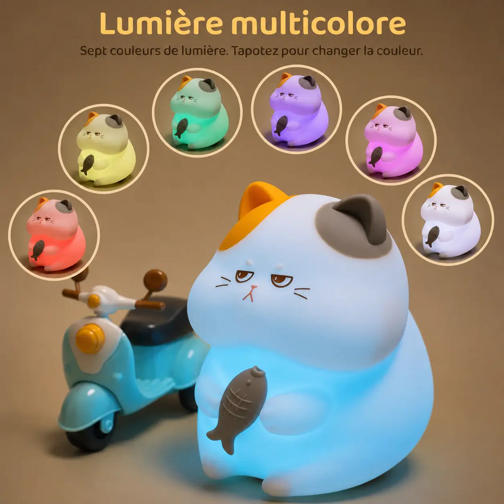 Infographie en français intitulée "Lumière multicolore" montrant une veilleuse chat en silicone qui diffuse une lueur bleu clair à côté d'un petit scooter miniature en plastique bleu. En arc de cercle au-dessus du produit, six vignettes illustrent les variations de couleur disponibles (jaune, vert, violet, rose, blanc et rouge), accompagnées du texte "Sept couleurs de lumière. Tapotez pour changer la couleur."