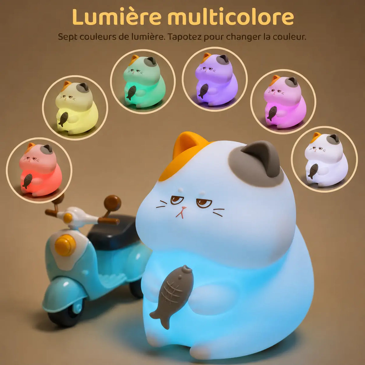 Infographie en français intitulée "Lumière multicolore" montrant une veilleuse chat en silicone qui diffuse une lueur bleu clair à côté d'un petit scooter miniature en plastique bleu. En arc de cercle au-dessus du produit, six vignettes illustrent les variations de couleur disponibles (jaune, vert, violet, rose, blanc et rouge), accompagnées du texte "Sept couleurs de lumière. Tapotez pour changer la couleur."