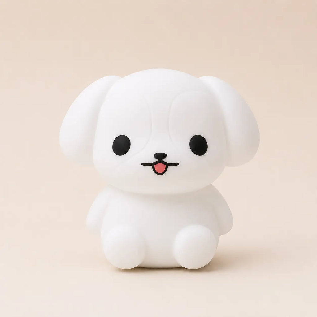Veilleuse en silicone en forme de petit chien blanc qui tire la langue, sur un fond beige neutre.