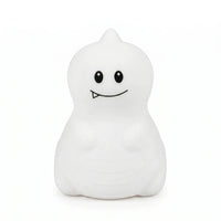 Veilleuse en silicone en forme de petit dinosaure blanc avec une petite dent, sur un fond blanc.