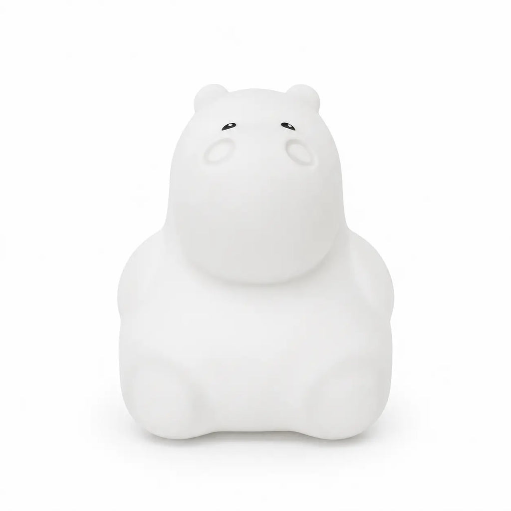 Veilleuse en silicone en forme de petit hippopotame blanc, sur un fond blanc.