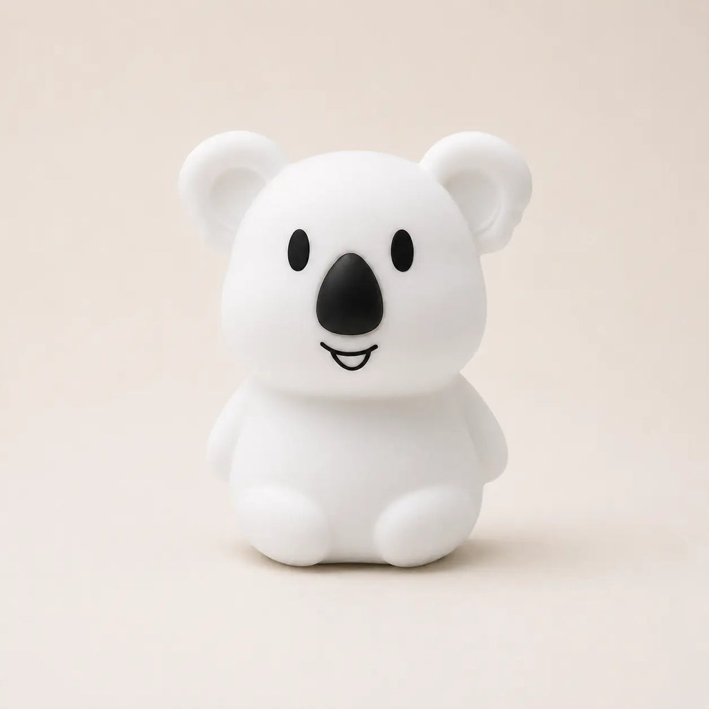 Veilleuse en silicone en forme de petit koala blanc, sur un fond beige neutre.