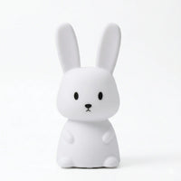 Veilleuse en silicone en forme de lapin blanc aux oreilles dressées, sur un fond blanc.
