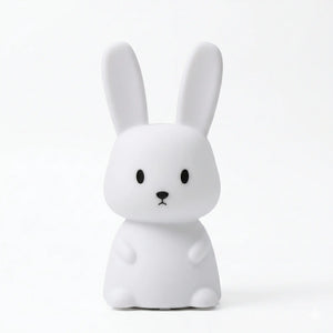 Veilleuse en silicone en forme de lapin blanc aux oreilles dressées, sur un fond blanc.