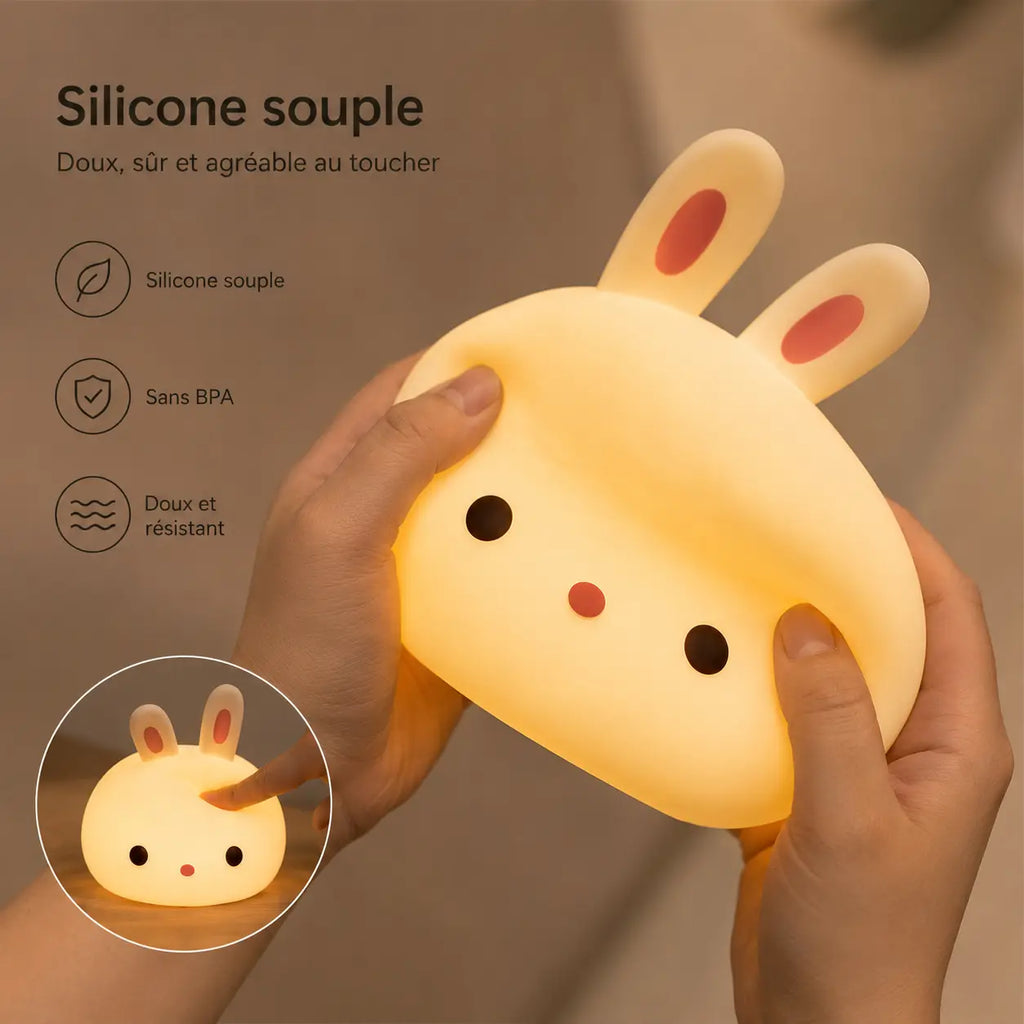 Infographie en français mettant en avant la texture d'une veilleuse lapin en silicone souple et allumée, pressée délicatement par deux mains. Le visuel intègre des icônes de réassurance avec les mentions "Silicone souple", "Sans BPA" et "Doux et résistant". Une vignette circulaire en bas à gauche montre un doigt tapotant le dessus du produit.