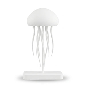 Veilleuse blanche en silicone en forme de méduse au design minimaliste et épuré, surélevée sur une tige centrale fixée à une base rectangulaire, présentée éteinte sur fond blanc.