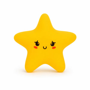 Veilleuse en silicone en forme de petite étoile jaune aux bords arrondis. Elle présente un visage de style kawaii dessiné de face avec de grands yeux expressifs aux reflets blancs, de petites joues rouges et un sourire timide, le tout présenté sur un fond blanc épuré.