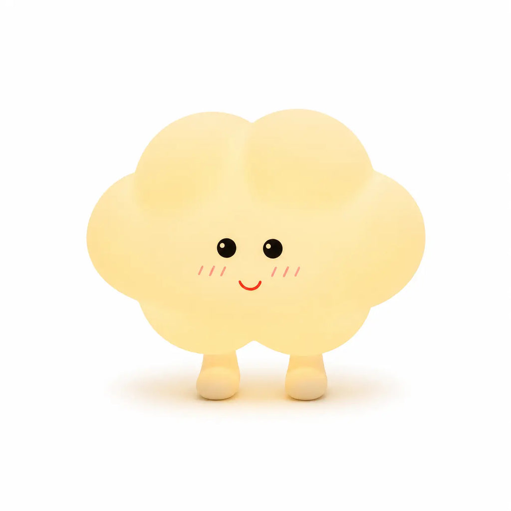 Veilleuse en silicone en forme de petit nuage jaune pâle tout rond doté de deux petits pieds. Elle présente un visage joyeux de style kawaii dessiné de face avec des yeux ronds noirs, de petites pommettes rosées et un grand sourire rouge, présentée sur un fond blanc épuré.
