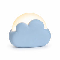 Veilleuse nomade en forme de nuage bleu diffusant une douce lumière chaude sur fond blanc