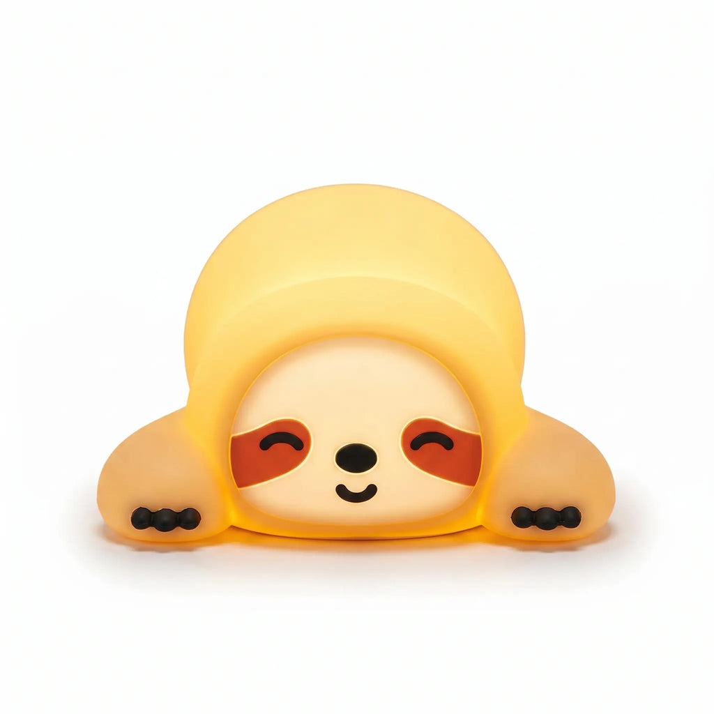 Veilleuse en silicone en forme de petit paresseux allongé tout mignon. Elle affiche un visage serein avec des yeux clos souriants, des taches marron caractéristiques et de petites griffes noires, diffusant une douce lueur jaune tamisée sur un fond blanc épuré.