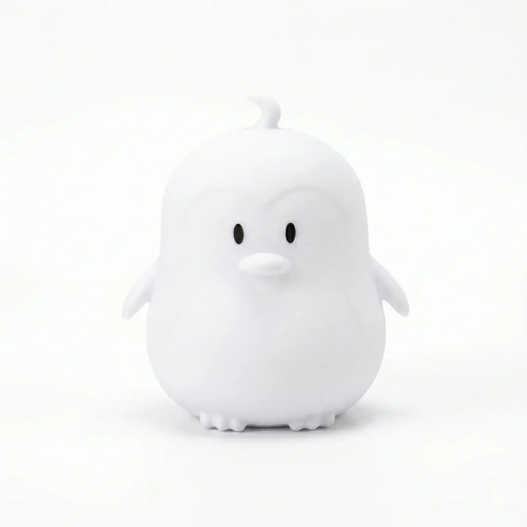 Veilleuse en silicone en forme de petit pingouin blanc sur fond blanc.