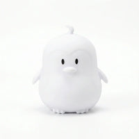 Veilleuse en silicone en forme de petit pingouin blanc sur fond blanc.