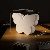 Infographie indiquant les dimensions de la veilleuse prise en forme de papillon posée sur un meuble en bois.