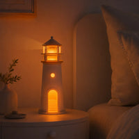 Veilleuse phare allumée sur une table de chevet diffusant une lumière chaude et apaisante dans une chambre
