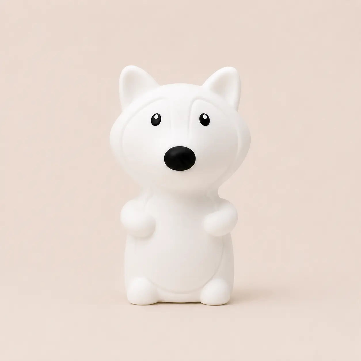 Veilleuse en silicone en forme de petit renard blanc, sur un fond beige neutre.