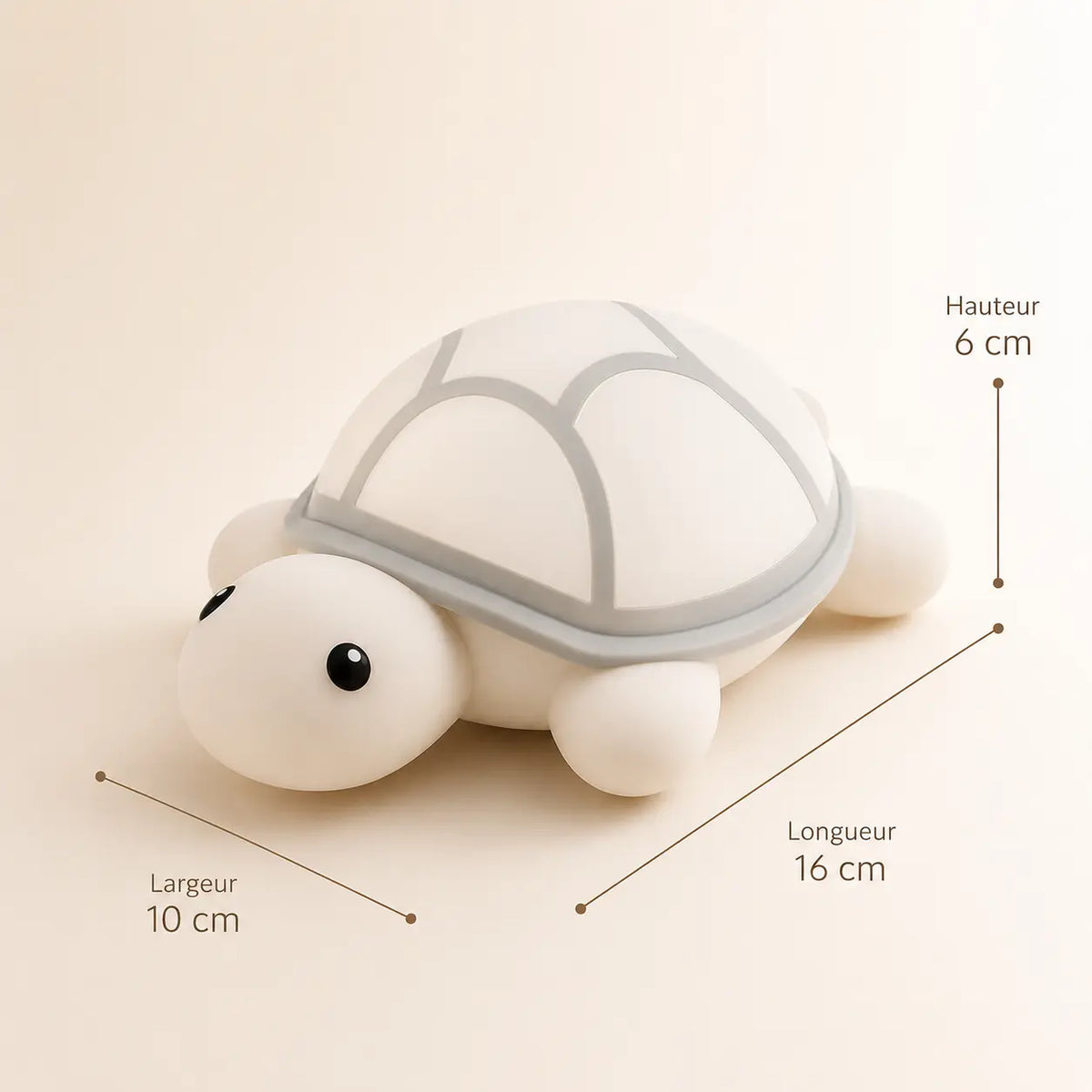 Schéma technique de la veilleuse tortue en silicone éteinte indiquant ses dimensions : hauteur de 6 cm, longueur de 16 cm et largeur de 10 cm, présentée de trois-quarts sur un fond crème épuré.